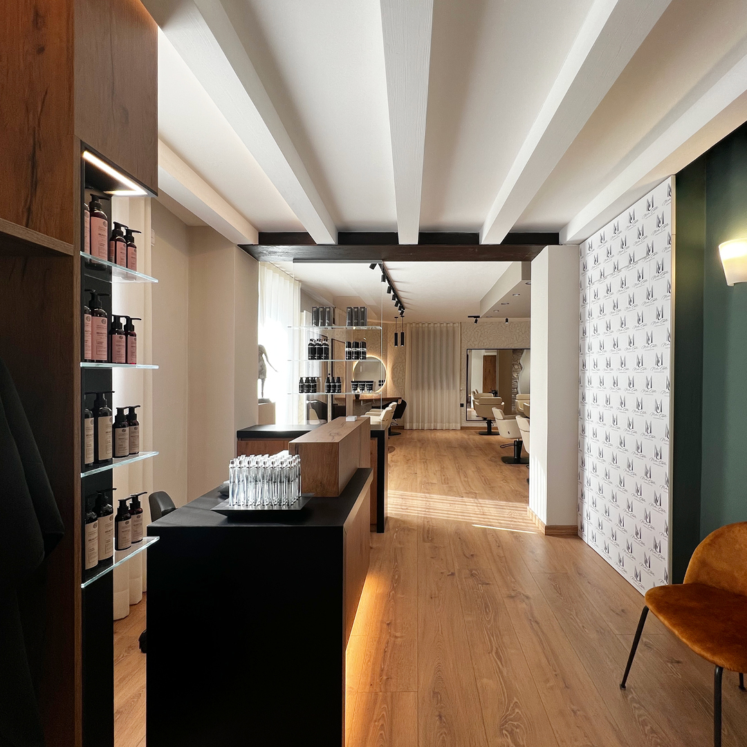 Immagine del bancone della reception, con bancone i legno e davanti due poltrone per salone d'attesa